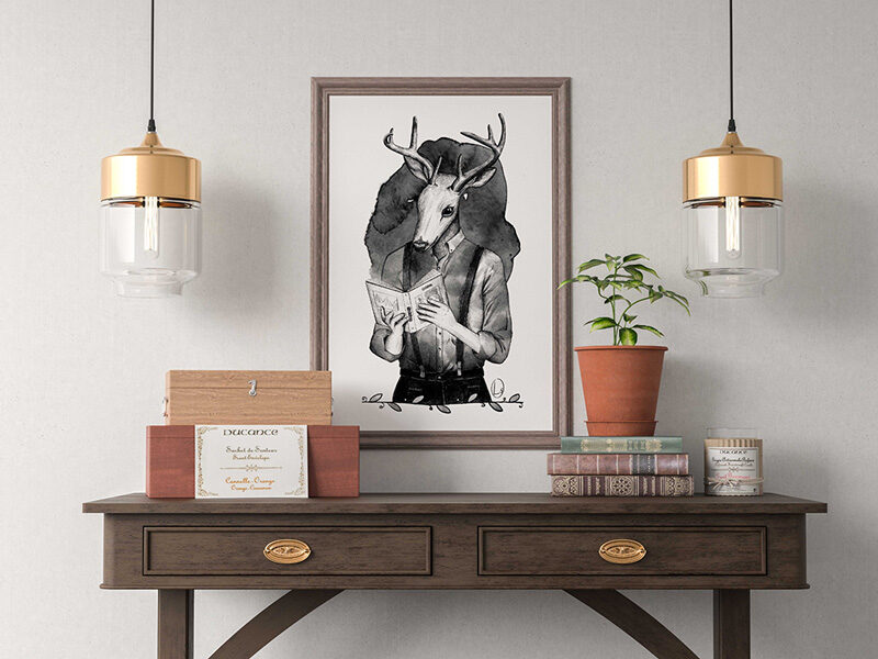 Una cornice con un'illustrazione che raffigura un antropomorfo con la testa da cervo mentre legge un libro. Sotto la cornice una scrivia con sopra piante e libri. Ai lati della cornice scendono due lampade dal soffitto.